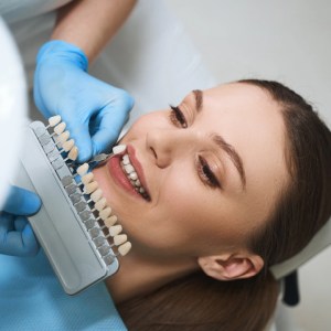 Dentist checking ultrathin veneers on a smiling patient at Aqua Dental Clinic